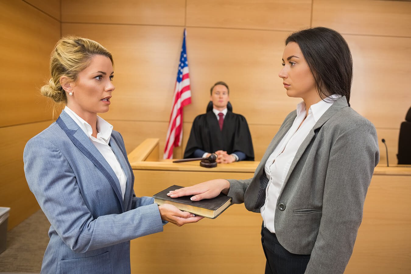 Articles Image of a witness being sworn in for testimony in front of a judge.