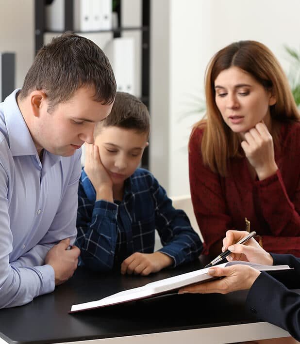 Benefits of Estate Planning means you choose your heirs, not the courts. Pictured is a family looking over legal documents.